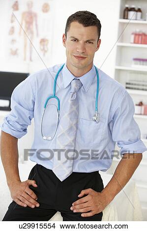 Picture - Young male doctor in consulting room. Fotosearch