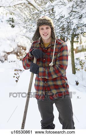 Stock Image - Young man clearing snow. Fotosearch