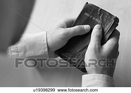 Stock Photo - Young man holding bible. Fotosearch