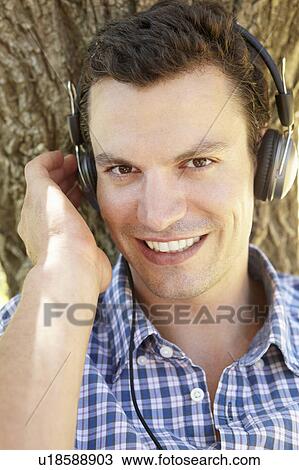 Stock Image - Young man listening music. Fotosearch