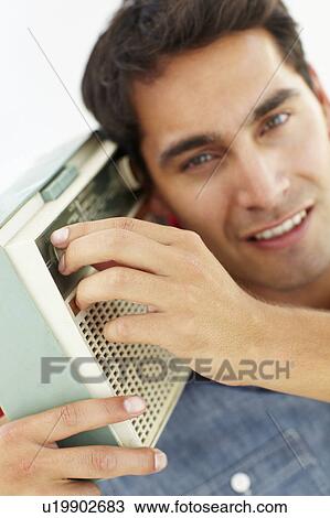 Stock Image - Young man listening to radio. Fotosearch