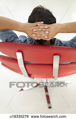Young man relaxing in red chair View Large Photo Image Stock Photograph - Young man relaxing in red chair. Fotosearch
