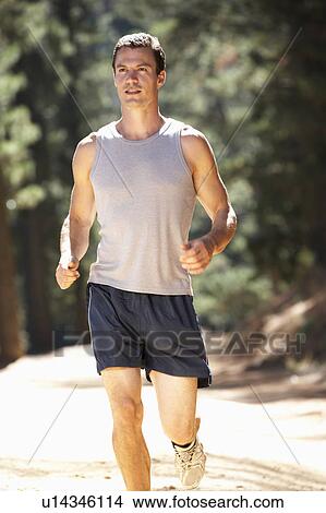 Young man running along country lane View Large Photo Image Picture - Young man running along country lane. Fotosearch
