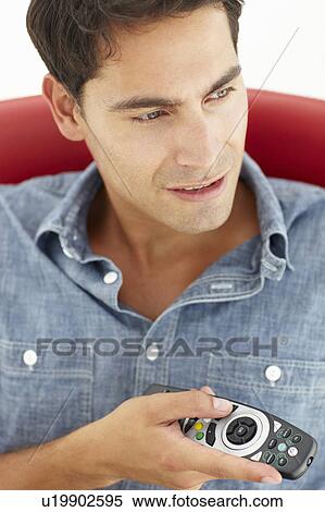 Stock Photography - Young man with remote control. Fotosearch