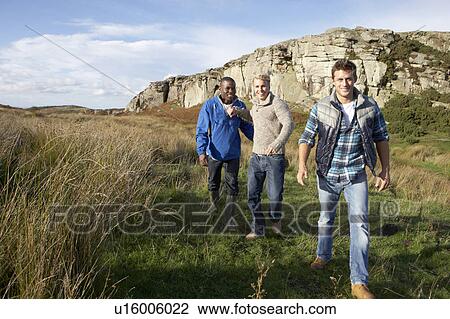 Young men on country walk View Large Photo Image Stock Image - Young men on country walk. Fotosearch