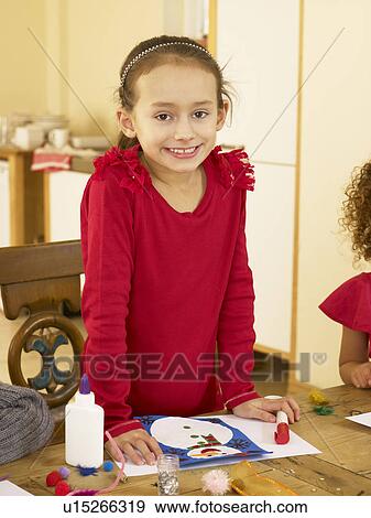 Stock Photo - Young mixed race child making Christmas cards. Fotosearch