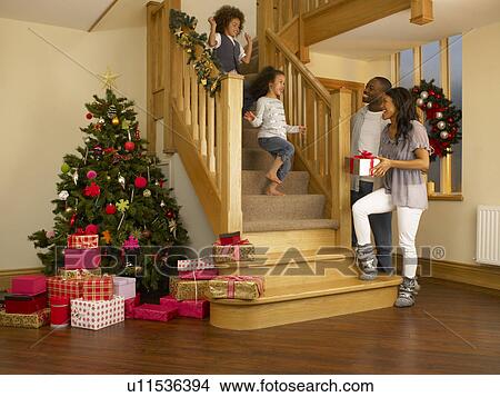 Young mixed race family on Christmas morning View Large Photo Image Picture - Young mixed race family on Christmas morning. Fotosearch