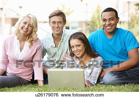 Young people using laptop outdoors View Large Photo Image Stock Photograph - Young people using laptop outdoors. Fotosearch