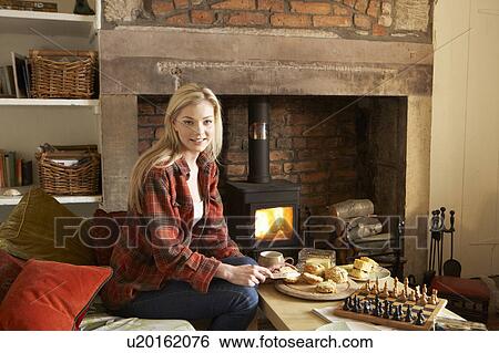 Young woman having tea by fire View Large Photo Image Stock Photograph - Young woman having tea by fire. Fotosearch