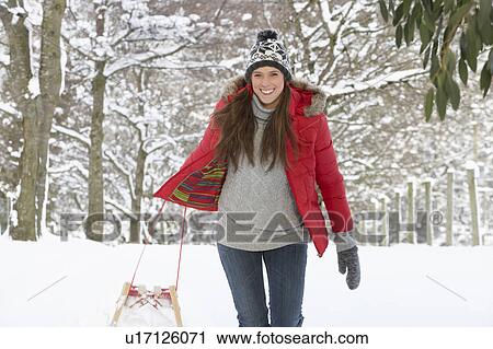 Young woman in snow with sledge View Large Photo Image Stock Image - Young woman in snow with sledge. Fotosearch