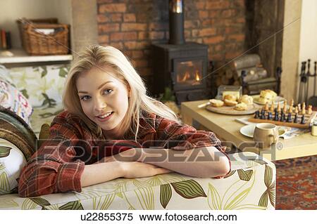 Stock Photography - Young woman relaxing by fire. Fotosearch