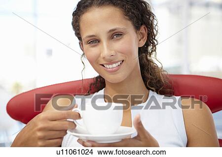 Young woman relaxing with cup of tea View Large Photo Image Picture - Young woman relaxing with cup of tea. Fotosearch