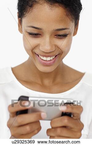 Stock Photo - Young woman using mobile phone. Fotosearch