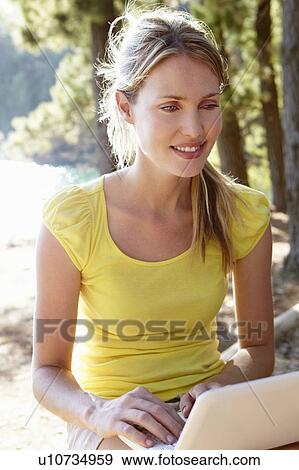 Stock Photo - Young woman with laptop. Fotosearch