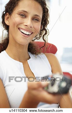 Picture - Young woman with remote control. Fotosearch