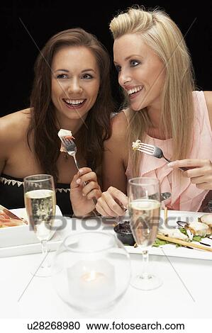 Stock Image - Young women in restaurant. Fotosearch