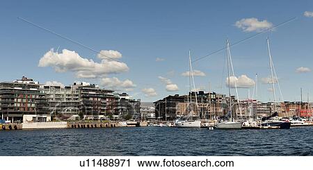 Stock Image - Boats with buildings at Oslo Harbor, Oslofjord, Oslo, Norway. Fotosearch