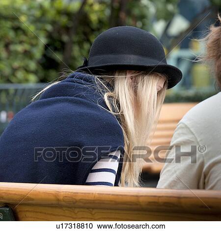 Stock Image - Couple sitting on a bench, Oslo, Norway. Fotosearch