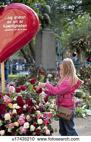Stock Image - Girl placing rose at a memorial near Oslo Cathedral, Oslo, Norway. Fotosearch