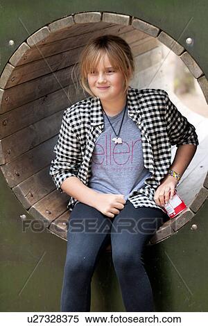 Stock Photography - Girl sitting in playground tunnel, Bergen, Norway. Fotosearch
