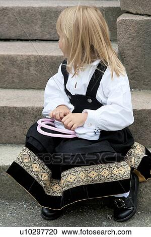 Stock Image - Girl sitting on steps holding a purse, Bergen, Norway. Fotosearch