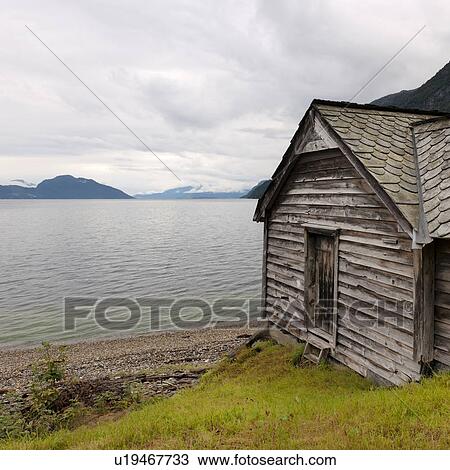 Stock Image - Log cabin at the riverside, Hardangervidda, Hardanger, Norway. Fotosearch