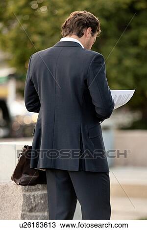 Rear view of a businessman reading a document, Oslo, Norway View Large Photo Image Stock Image - Rear view of a businessman reading a document, Oslo, Norway. Fotosearch