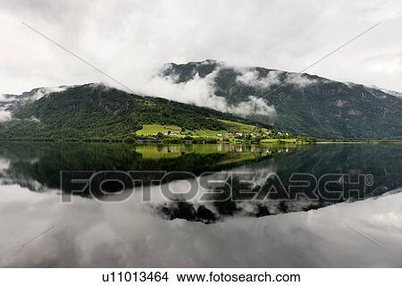 Picture - Reflection of mountain with clouds in the lake, Granvinsvatnet, Granvin, Hordaland County, Norway. Fotosearch