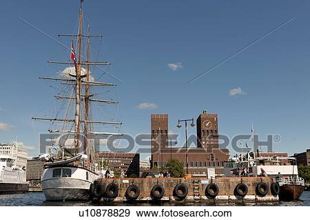 Sailing ship with town hall at Oslo Harbor, Oslo City Hall, Oslo, Norway View Large Photo Image Stock Photo - Sailing ship with town hall at Oslo Harbor, Oslo City Hall, Oslo, Norway. Fotosearch