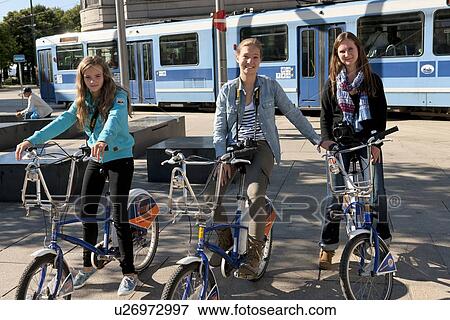 Three girls sitting on bicycles side by side, Oslo, Norway View Large Photo Image Stock Photo - Three girls sitting on bicycles side by side, Oslo, Norway. Fotosearch