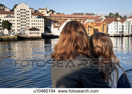 Picture - Woman with her daughter on boat and looking at city, Bergen, Norway. Fotosearch