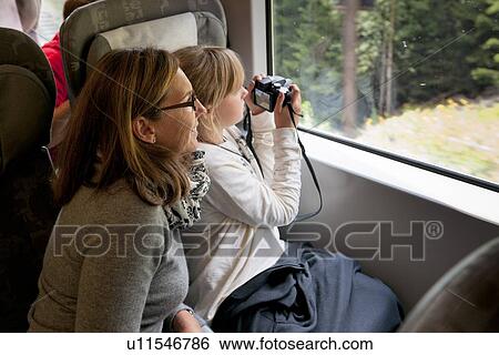 Woman with her daughter taking a picture with a camera through vehicle window, Highlands, Norway View Large Photo Image Stock Photograph - Woman with her daughter taking a picture with a camera through vehicle window, Highlands, Norway. Fotosearch