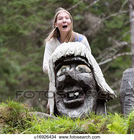 Picture - Woman with wooden Troll in a park, Bergen, Norway. Fotosearch