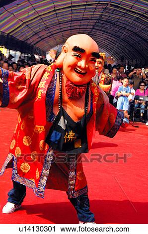 Stock Image - Performer in costume dancing on a street. Fotosearch