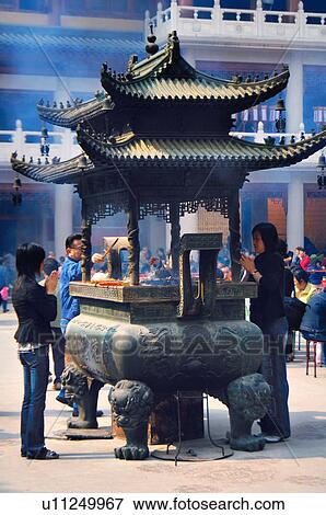 Three people praying around incense burner View Large Photo Image Stock Photo - Three people praying around incense burner. Fotosearch