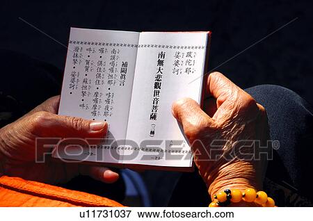 Stock Photo - Monk praying with Buddhist scripture. Fotosearch