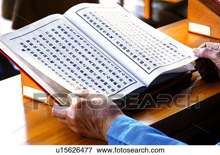 Stock Photo - Monk praying with Buddhist scripture. Fotosearch