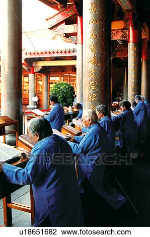 Stock Image - Monks praying with Buddhist scripture. Fotosearch