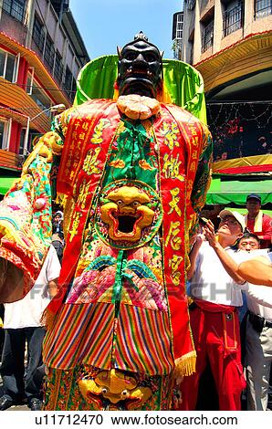 Stock Image - People holding a sculpture during mazu festival, China. Fotosearch