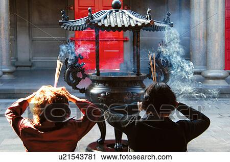Rear view of a couple holding incense sticks View Large Photo Image Stock Image - Rear view of a couple holding incense sticks. Fotosearch