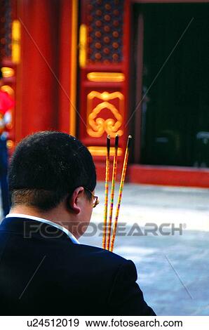 Rear view of a man holding incense sticks View Large Photo Image Stock Photo - Rear view of a man holding incense sticks. Fotosearch