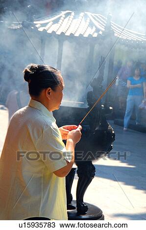 Side profile of a woman holding incense sticks View Large Photo Image Stock Image - Side profile of a woman holding incense sticks. Fotosearch