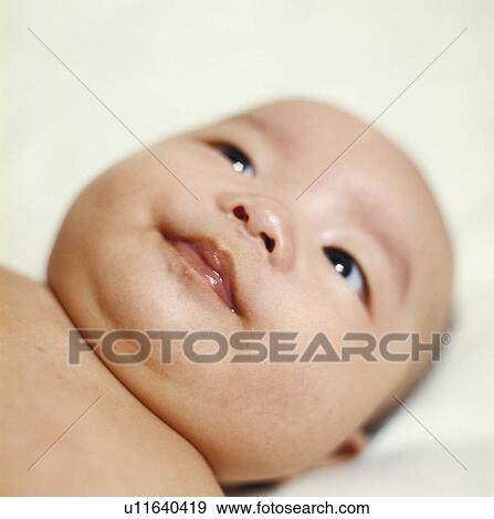 Close-up of a baby boy lying on the bed View Large Photo Image Stock Photo - Close-up of a baby boy lying on the bed. Fotosearch