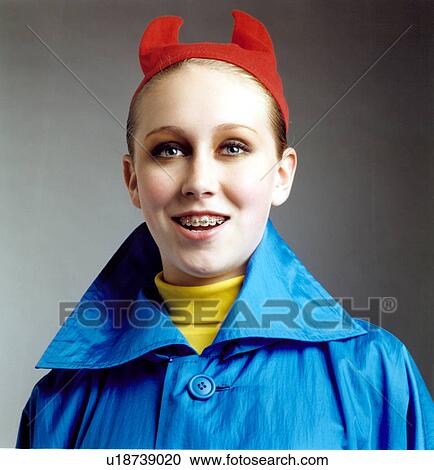 Stock Image - Close-up of a woman smiling in devil costume. Fotosearch