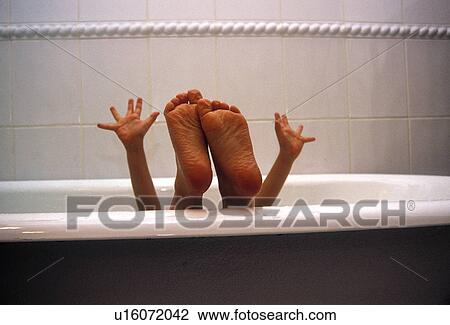 Stock Image - Kid in a bathtub showing his sole of feet and hands. Fotosearch
