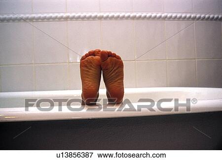 Stock Photo - Kid in a bathtub showing his sole of feet. Fotosearch