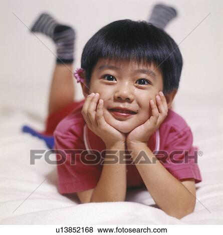 Portrait of a boy lying on the bed View Large Photo Image Stock Photo - Portrait of a boy lying on the bed. Fotosearch