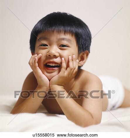 Stock Photography - Portrait of a boy lying on the bed. Fotosearch