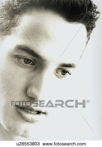 Close-up of a young man looking down View Large Photo Image Stock Image - Close-up of a young man looking down. Fotosearch