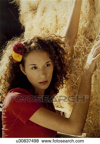 Close-up of a young woman leaning against a rock View Large Photo Image Stock Photo - Close-up of a young woman leaning against a rock. Fotosearch